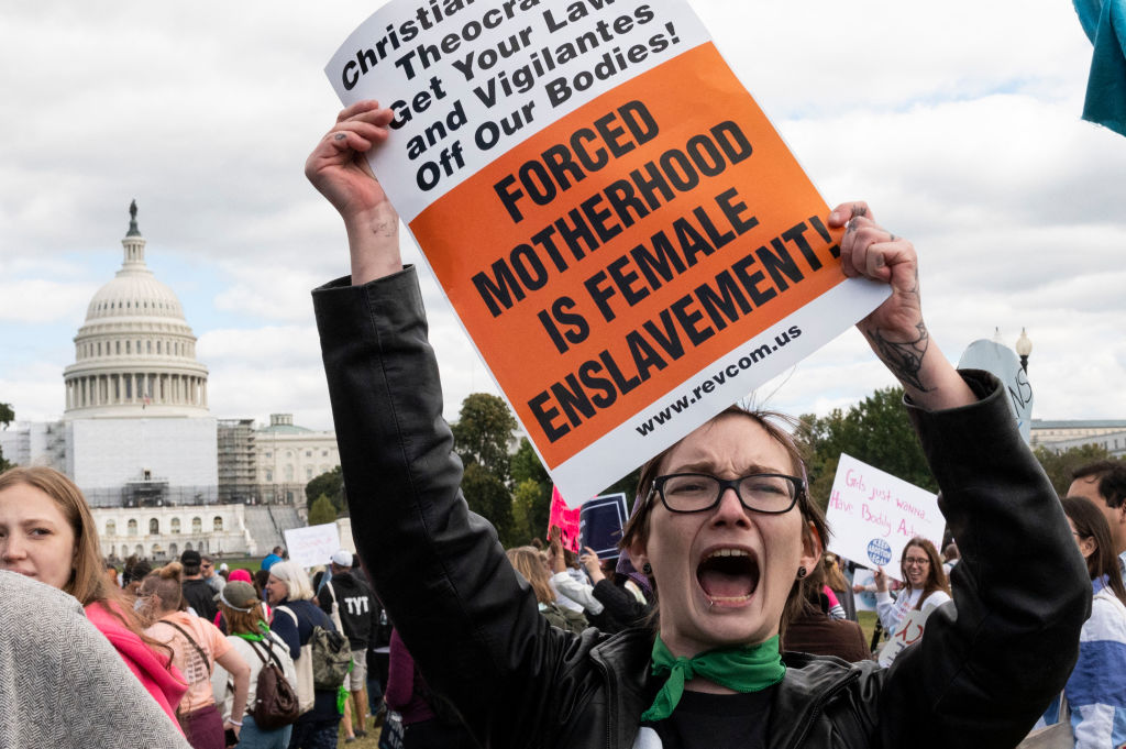 An abortion rights demonstrator yells near the US Capitol while participating in the annual Women's March to support Women's Rights in Washington, DC, October 8, 2022. - Thousands of people gathered in Washington and in cities across the country to rally for reproductive rights, one month before the midterm elections. (Photo by ROBERTO SCHMIDT / AFP) (Photo by ROBERTO SCHMIDT/AFP via Getty Images)