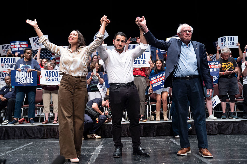 DETROIT, MICHIGAN - JULY 18: (L-R) U.S. Rep. Alexandria Ocasio-Cortez (D-NY), Michigan Democratic candidate for Senate Abdul El-Sayed and U.S. Sen. Bernie Sanders (I-VT) greet the crowd after El-Sayed spoke at The People V. The Powerful rally at the Detroit Opera House on July 18, 2026 in Detroit, Michigan. Sanders, Ocasio-Cortez and others joined El-Sayed to rally the crowds. (Photo by Sarah Rice/Getty Images)
